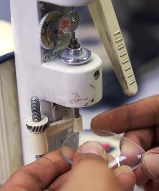 A finished lens checked against the drill