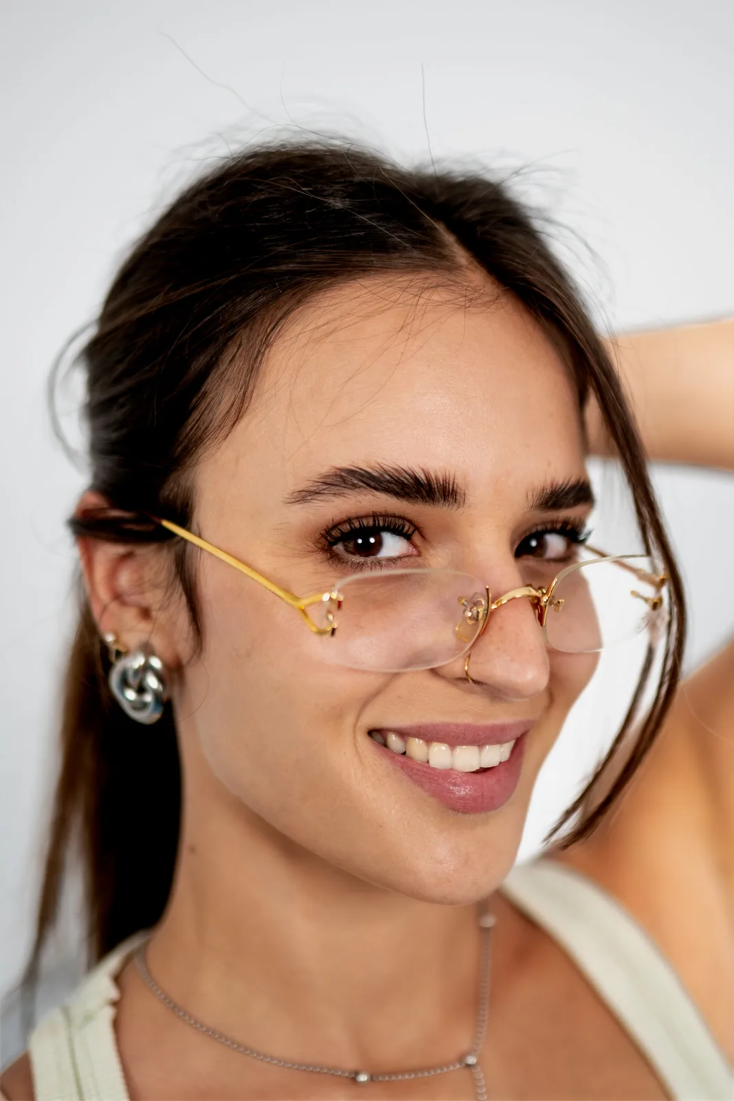 A happy Optirama customer trying on rimless gold frames